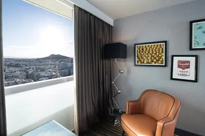 a hotel room with a chair and a window at President Hotel Athens in Athens