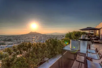 a view of a city from a rooftop with a sunset at President Hotel Athens in Athens