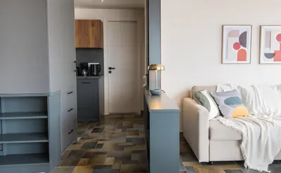 a living room with a couch and a kitchen at Wonder Apartment over the Sea in Athens