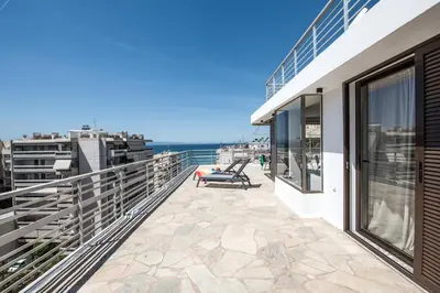 a balcony with a bench on top of a building at Wonder Apartment over the Sea in Athens