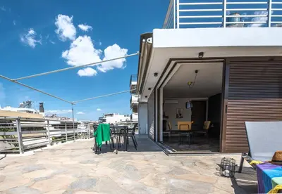 a patio with a table and chairs next to a building at Wonder Apartment over the Sea in Athens