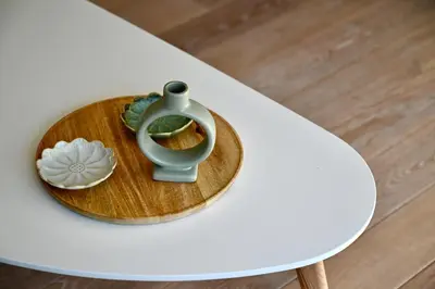 a vase on a wooden plate on a white table at Bright and comfy apartment in the heart of Athens in Athens