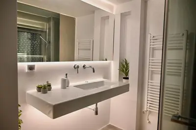 a white bathroom with a sink and a mirror at Bright and comfy apartment in the heart of Athens in Athens