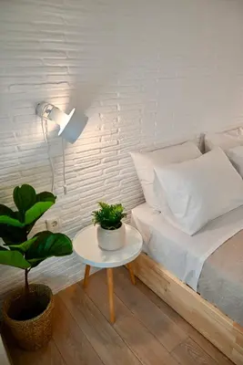 a bedroom with a bed and a table with a plant at Bright and comfy apartment in the heart of Athens in Athens
