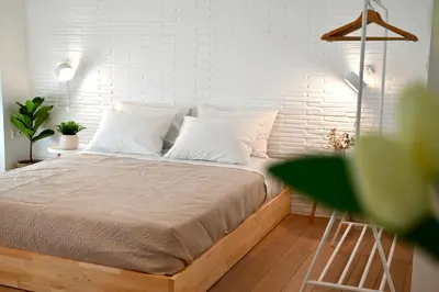 a bed in a bedroom with a white brick wall at Bright and comfy apartment in the heart of Athens in Athens