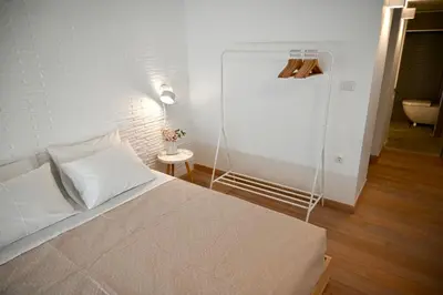 a white bedroom with a bed and a lamp at Bright and comfy apartment in the heart of Athens in Athens