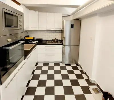 a kitchen with a checkered floor and a refrigerator at Alimos Cozy Studio in Athens