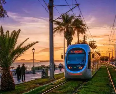 a blue train on the tracks next to a beach at Alimos Cozy Studio in Athens