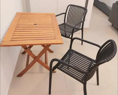 a wooden table and two chairs next to a table and a bench at Alimos Cozy Studio in Athens