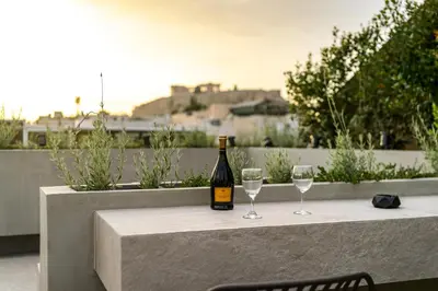 a bottle of wine sitting on a table with two glasses at The Dorians in Athens