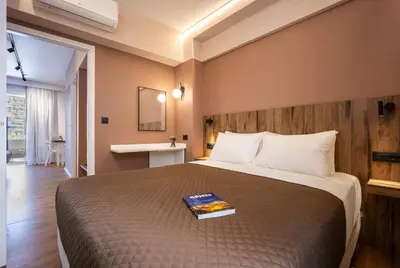 a bedroom with a bed with a book on it at The Dorians in Athens