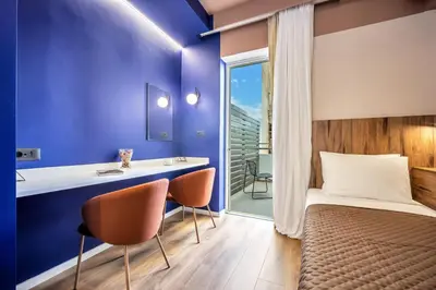 a bedroom with a bed and a desk and chairs at The Dorians in Athens