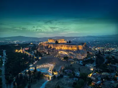 an aerial view of the acropolis at night at The Dorians in Athens