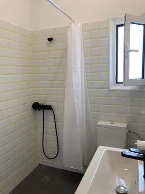 a bathroom with a shower with a white shower curtain at Jenny's Central Apartment in Athens