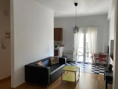 a living room with a black couch and a table at Jenny's Central Apartment in Athens