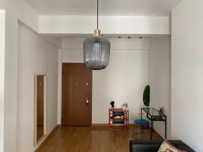 a living room with a couch and a pendant light at Jenny's Central Apartment in Athens