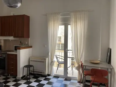 a kitchen with a sliding glass door to a balcony at Jenny's Central Apartment in Athens