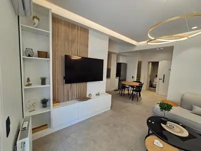 a living room with a flat screen tv on a wall at CAS Athens Center Apartments in Athens