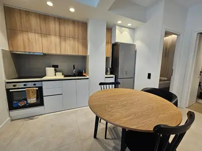 a kitchen with a wooden table and a table and chairs at CAS Athens Center Apartments in Athens