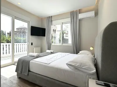 a bedroom with a bed and a large window at CAS Athens Center Apartments in Athens