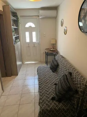 a living room with a couch in front of a door at George's Apartment in Athens
