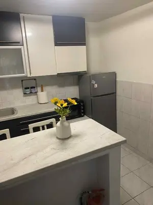 a kitchen with a counter with a vase with flowers on it at George's Apartment in Athens