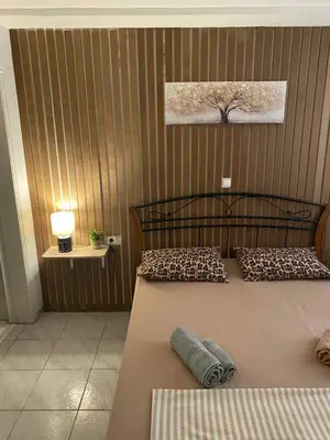 a bedroom with a bed and a tree on the wall at George's Apartment in Athens