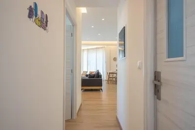 a hallway with a door leading to a living room at Elegant 2BR with Jacuzzi & Acropolis View in Athens
