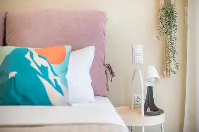 a bedroom with a bed with a pillow and a table at Elegant 2BR with Jacuzzi & Acropolis View in Athens