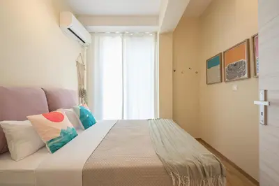 a bedroom with a bed with pillows and a window at Elegant 2BR with Jacuzzi & Acropolis View in Athens