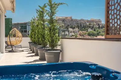 a row of potted plants on a balcony with a view ofhens at Elegant 2BR with Jacuzzi & Acropolis View in Athens