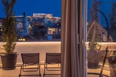 two chairs on a balcony with a view of a city at Elegant 2BR with Jacuzzi & Acropolis View in Athens