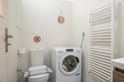 a bathroom with a washing machine and a toilet at Elegant 2BR with Jacuzzi & Acropolis View in Athens