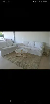 a living room with white couches and a coffee table at Vouliagmeni Kavouri Beach front in Athens