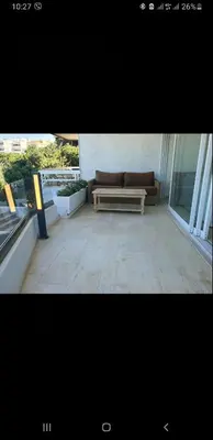 a living room with a couch on a balcony at Vouliagmeni Kavouri Beach front in Athens