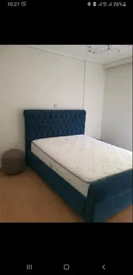 a bed in a room with a blue bed frame at Vouliagmeni Kavouri Beach front in Athens