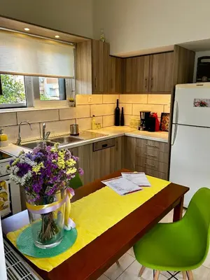 a kitchen with a table with a vase of flowers on it at Flower House in Koropi-near airport in Koropíon