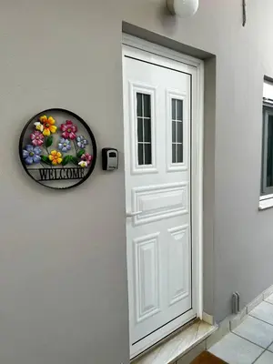 a white door with a welcome sign next to it at Flower House in Koropi-near airport in Koropíon