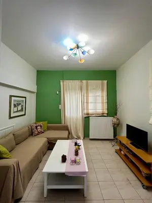 a living room with a couch and a ceiling fan at Flower House in Koropi-near airport in Koropíon