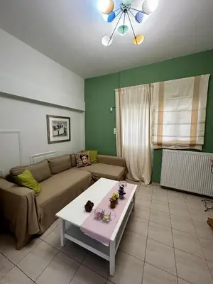 a living room with a couch and a table at Flower House in Koropi-near airport in Koropíon