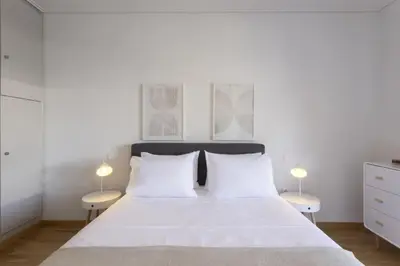 a bedroom with a large white bed with two lamps at Afroditis58-64 in Athens