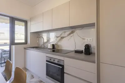 a kitchen with white cabinets and a stove top oven at Afroditis58-64 in Athens