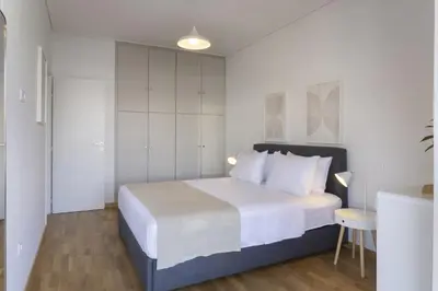 a bedroom with a large bed with white walls at Afroditis58-64 in Athens
