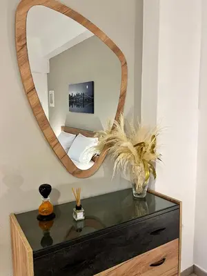 a mirror on top of a dresser in a room at Lia's luxury apartment - near airport in Koropíon