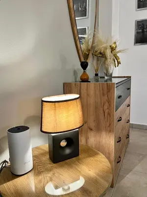 a lamp sitting on a table next to a dresser at Lia's luxury apartment - near airport in Koropíon