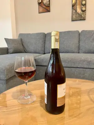 a bottle of wine and a glass on a table at Lia's luxury apartment - near airport in Koropíon