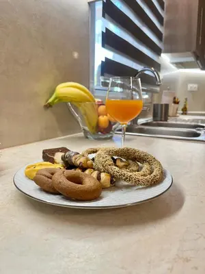 a plate of food on a counter with a glass of orange juice at Lia's luxury apartment - near airport in Koropíon