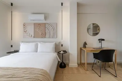 a bedroom with a bed and a desk with a chair at Acropolis View Plunge Pool Loft in Athens
