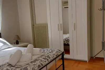 a bedroom with a bed with white sheets and a mirror at Dalia Apartment- 3 BD,1 BATH in Athens