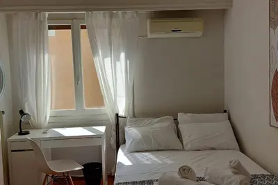 a bedroom with a bed and a desk and a window at Dalia Apartment- 3 BD,1 BATH in Athens